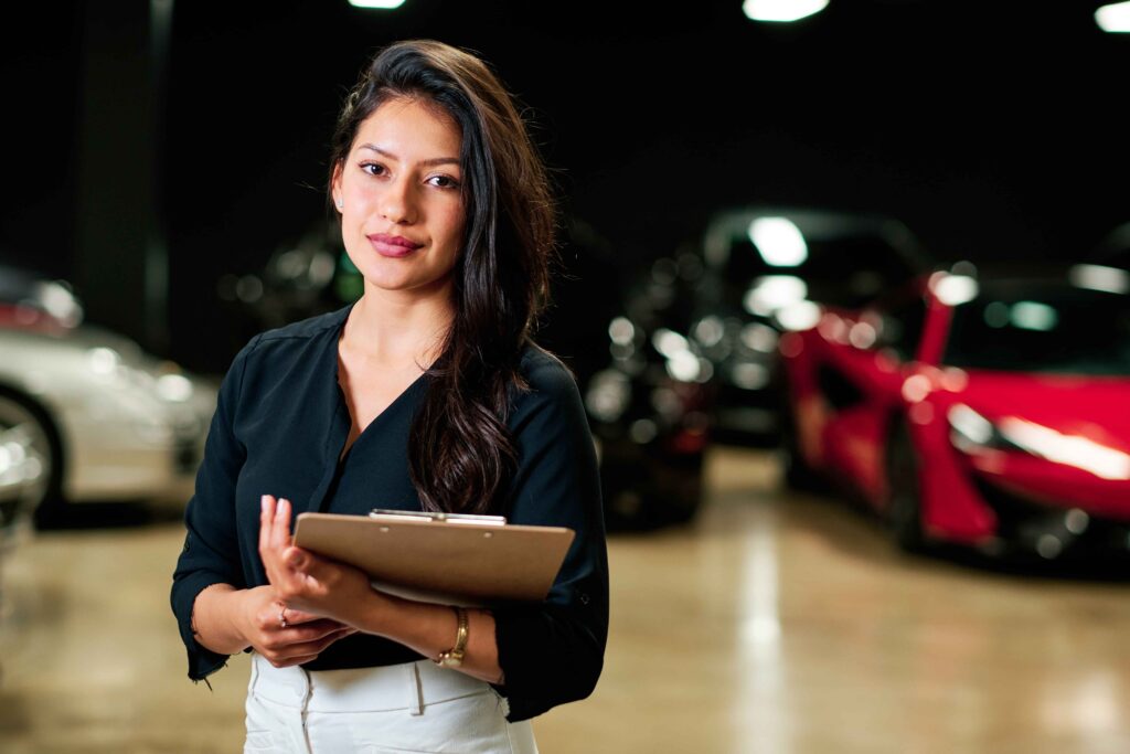 Femme posant avec un bloc-notes dans une concession automobile